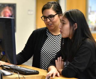 Advisor assisting student on computer