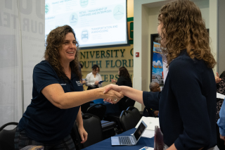 Student and employer shaking hands at job fair