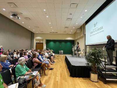 OLLI attendees seated in the ballroom with a speaker onstage