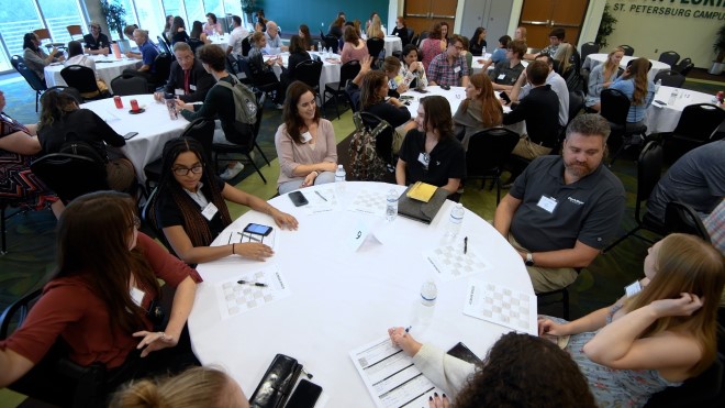 People in a conference seated at tables talking