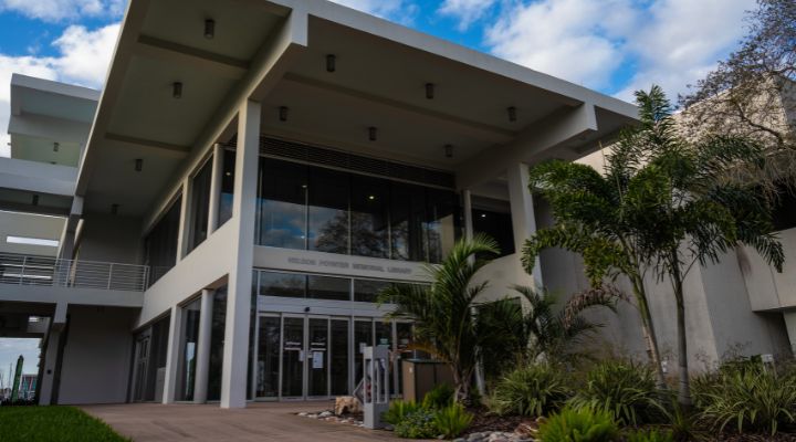 Outside picture of large library with greenery in front