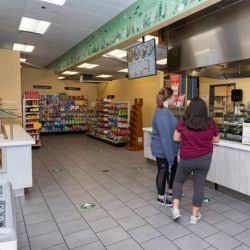 Two students standing in a convenience store.