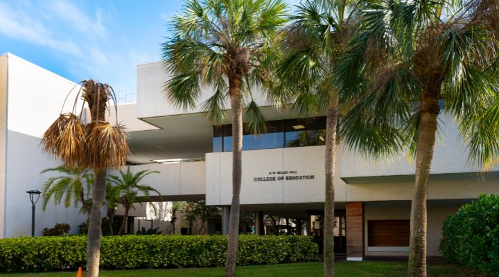 Outside shot of College of Education Building with three palm trees in front.
