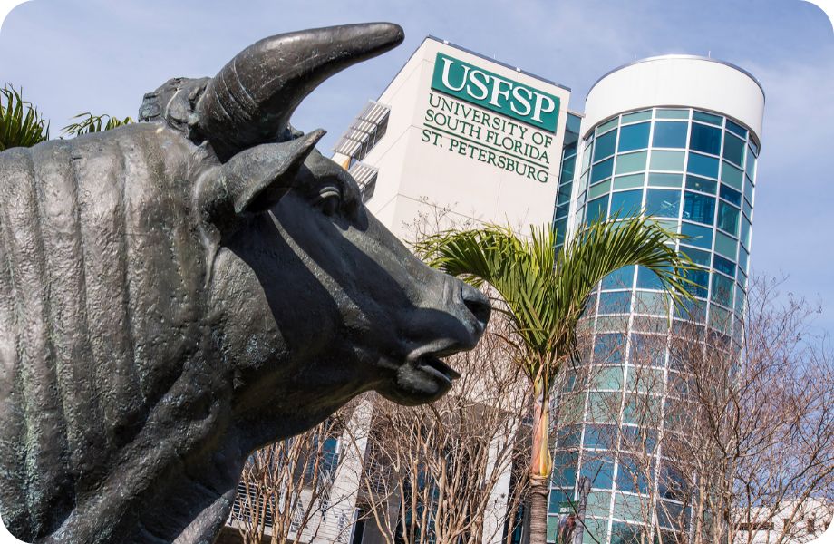 Statue of a bull in front of large campus building