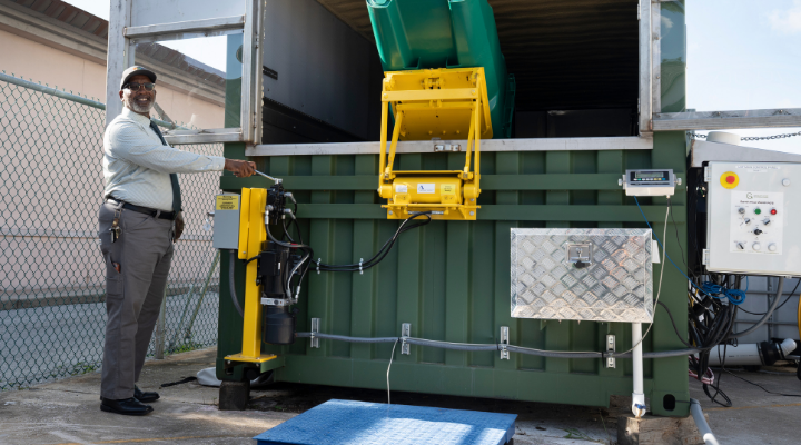 Man pulling lever on large-scale composter