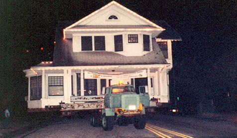 A flat bed truck re-locating Snell House at night