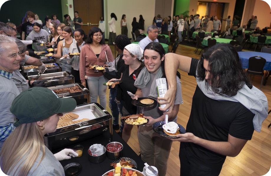 Students in cafeteria line serving themselves breakfast