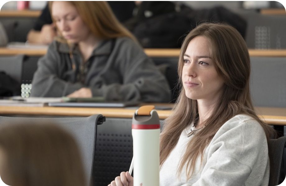 Student sitting in lecture room, listening. 