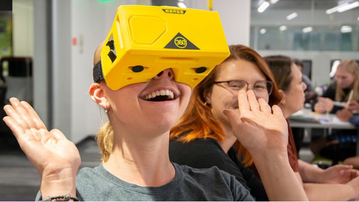 student in a classroom wearing virtual reality headset