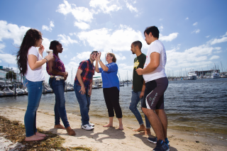 professor with students doing research on the beach