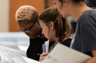 3 female students looking at paperwork