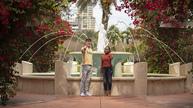 students in front of of fountain on campus