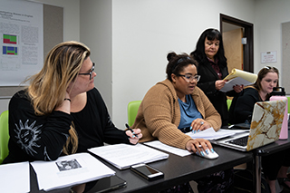 students sitting at a table with papers in front of them