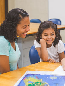 student teacher and young girl in classroom setting