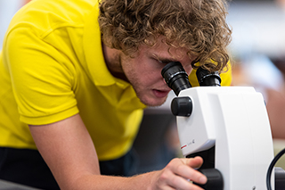 student looking through a microscope