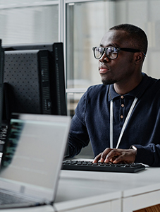 Man sitting at a table with a laptop open in front of him.