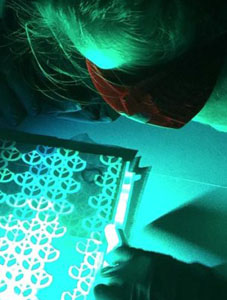close-up of student examing light sensitive film in darkroom