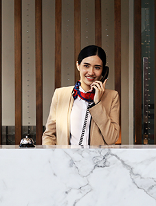 Woman answering a phone at a hotel desk