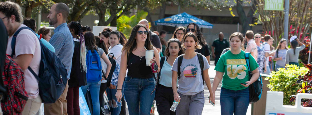 large group of people milling about on campus