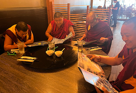 group of 4 monks reading Innovation Magazine sitting at a table