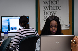 female student working intently on laptop computer