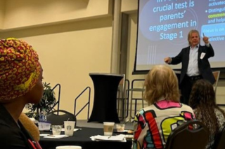 Jamie McHale standing on a stage presenting at a recent event