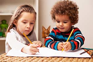 Two children writing on paper