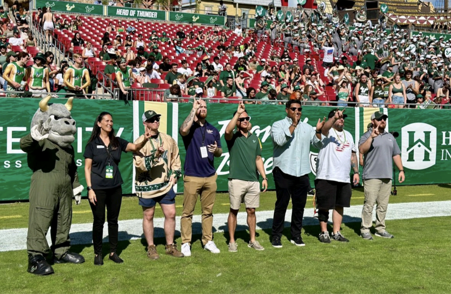 Rocky and people from OVS posing for a photo inside Raymond James Stadium