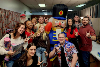 A group of people posing with a toy soldier