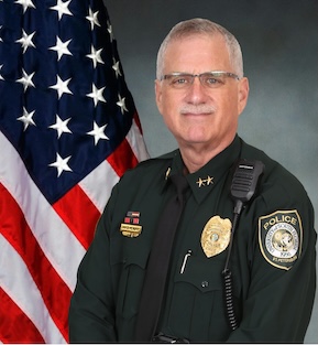 Chief David Hendry in uniform in front of the flag of the United States