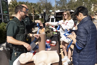 Two officers and two students around a table with safety equipment on it