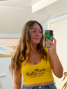 Student wearing yellow shirt taking a selfie.