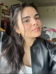 Student wearing black leather jacket looking directly at camera.