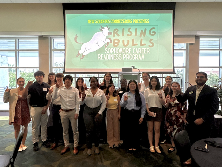 a group of people in front of a screen displaying Rising Bulls