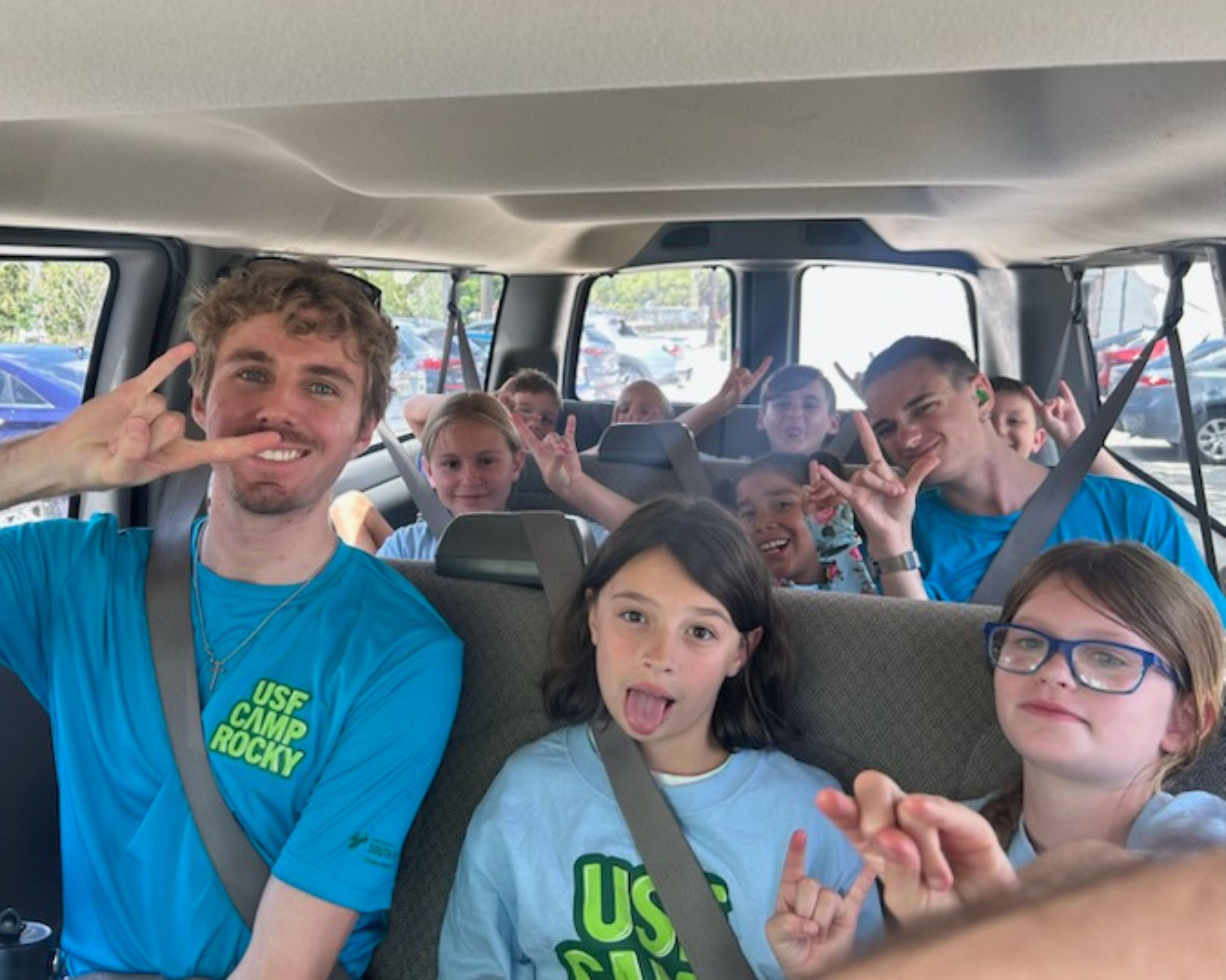 Group of students in a van posing for the camera