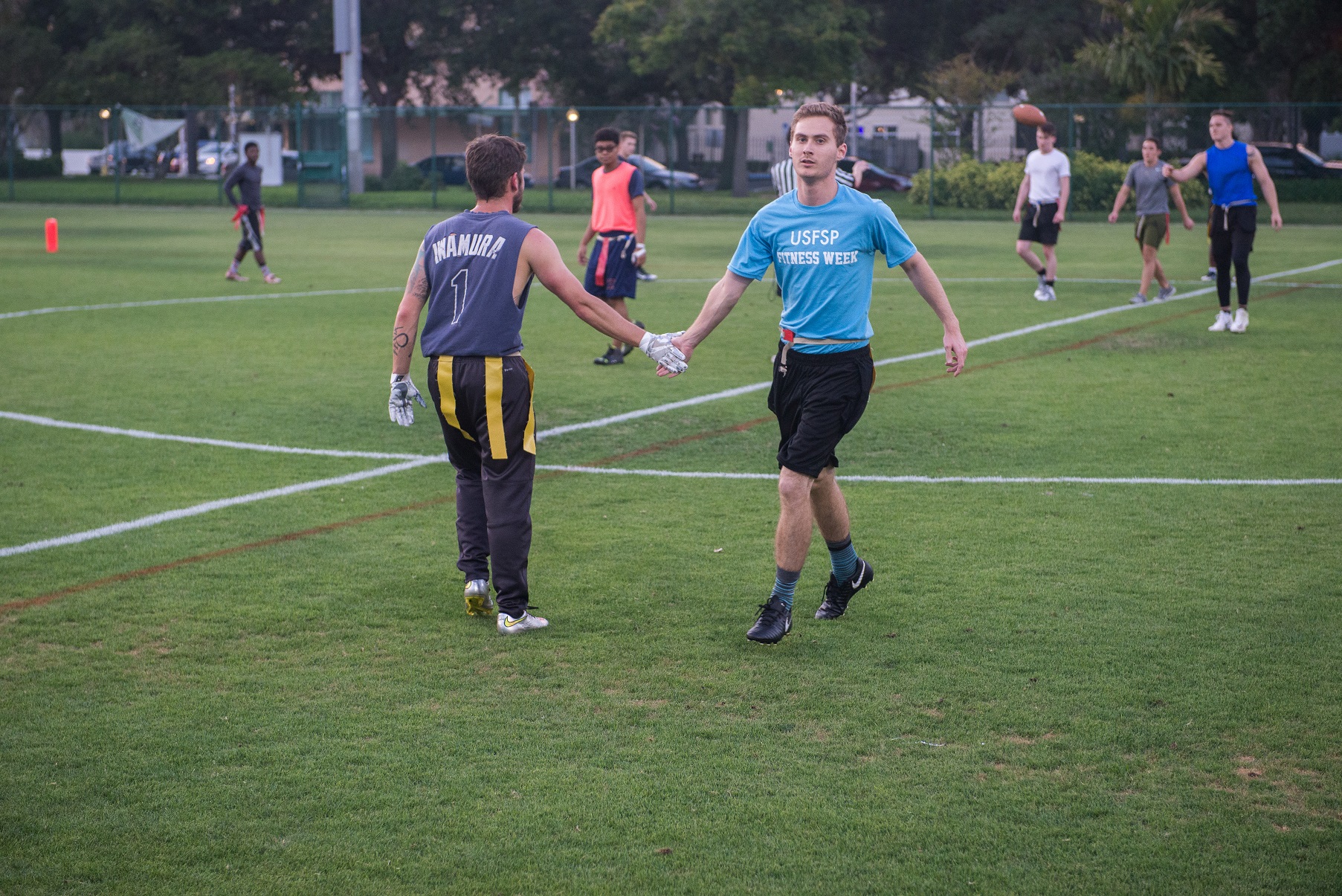 students high five on flag football field