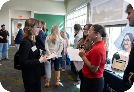 Students at an internship fair talking to representatives from various companies