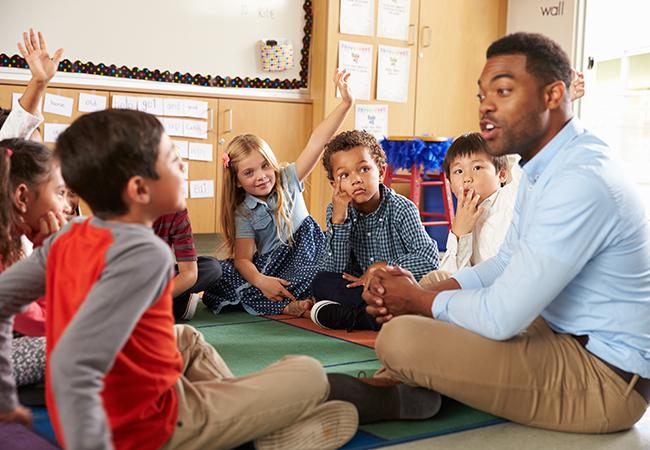 Teacher on ground with students in classroom