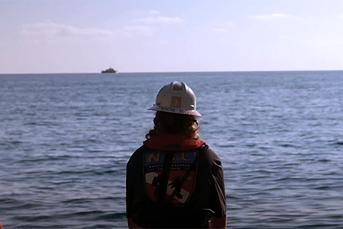 Journalism student documents marine science out at sea.