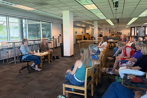 dr. elliot speaking to a group of people in the library