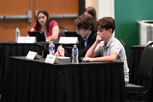 youth sitting at table participating in civics bee