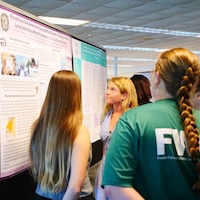 Students view poster findings at Summer Research Symposium.