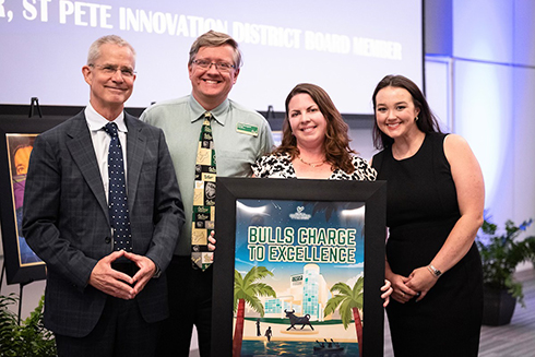 thomas smith, david rosengrant, colleen cherry, lexi wilson holding a printed poster in a frame