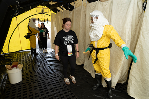 woman inside tent with worker in hazmat suit