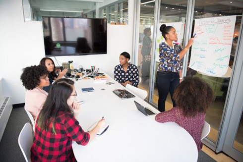 Women sitting at a conference table working together. 