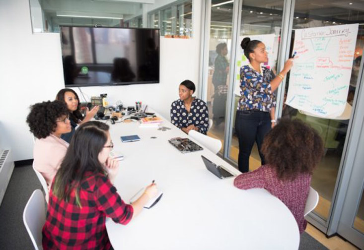 Women sitting at a conference table working together. 