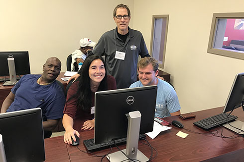 Dr. Fellows helps two VITA students prepare taxes for a Pinellas County resident.