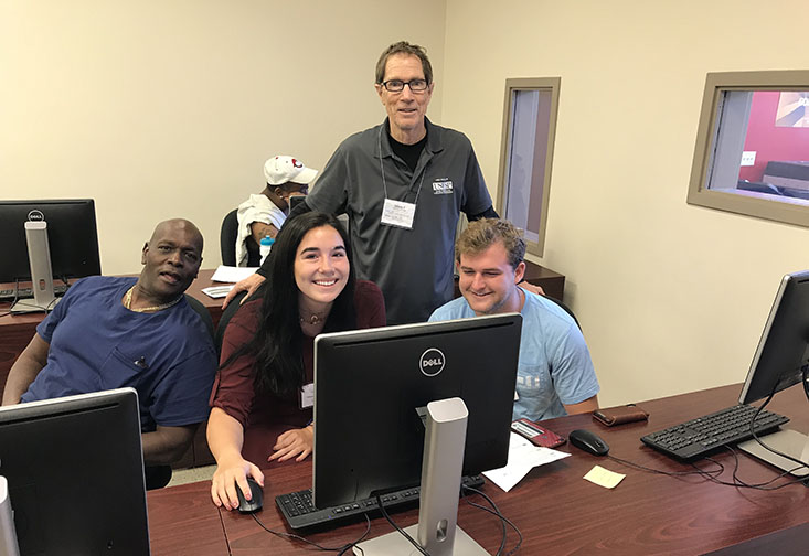 Dr. Fellows helps two VITA students prepare taxes for a Pinellas County resident.