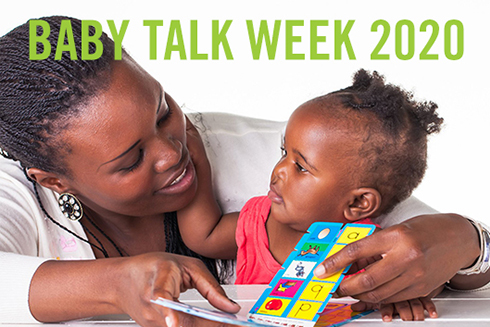 Adult woman reading a book to a young child.