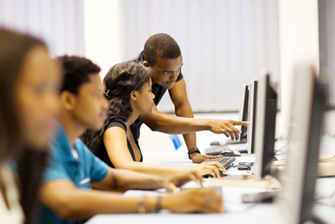 Teacher working with students on a computer